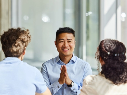 two men and woman talking at a table zoomed in